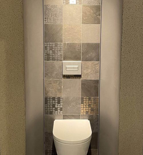 Beige tegels met wit toilet